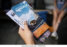 a person holding up a brochure in their hand