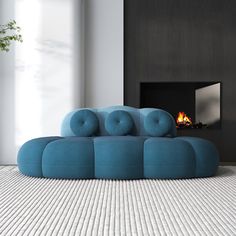 a blue couch sitting on top of a white floor next to a fire place in a living room