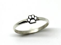 Solid silver ring for animal lovers .It is very nice on its own and it is great as a stack ring .The paw sits on a half-rounded silver ring/ A great gift for a good friend or a personal treat, in the name of love. Paw size: 5 mm (0.2 inch). Thickness of the ring: 2 mm  *Please select your size before checkout *  *All my jewelries come in a recycled paper gift box. -About my work- From wax to polish all work is done by hand (Carving, soldering, stone inlay etc.).I use semi- precious stones and cr Adjustable Silver Jewelry With Paw Print, Silver Cat Design Promise Ring, Silver Ring With Cat Design For Anniversary, Silver Promise Ring With Cat Design, Silver Anniversary Ring With Cat Design, Silver Jewelry With Paw Print, Paw Ring, In The Name Of Love, Sterling Silver Cat