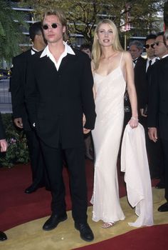 a man and woman standing next to each other on a red carpet at an event