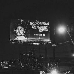 a billboard with a man's face on it in the middle of a city at night