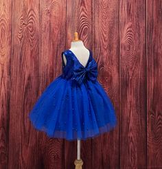 Our enchanting Knee Length flower girl dresses are sure to turn heads! This beautiful elegant sophisticated dress is handmade, the bodice consists of Royal Blue Sequin, the back of the dress consists of an open V-back with a zipper. The big bow is detachable. The skirt consists of 4 layers of tulle with the top layer consisting with sowed in Royal Blue pearl beads. The fifth layer is made of lining with crinoline for fullness.  This dress is perfect for any occasion!  Dress Is Pictured with a pe Elegant Royal Blue Princess Dress For Party, Blue Elegant Princess Dress For Birthday, Blue Princess Dress With Fitted Bodice And Tulle, Royal Blue Fitted Princess Dress For Wedding, Blue Tulle Princess Dress With Fitted Bodice, Elegant Blue Dress For Birthday, Elegant Sleeveless Birthday Pageant Dress, Elegant Blue Princess Dress For Birthday, Elegant Blue Tutu Dress For Wedding