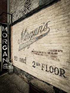 an old sign on the side of a building that says morgan's 2 n st floor