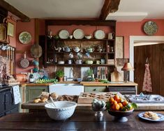 an old fashioned kitchen with plates and bowls on the table