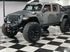 a gray jeep is parked on a checkered floor