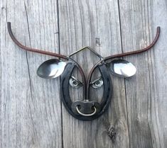 a metal cow head mounted to the side of a wooden wall