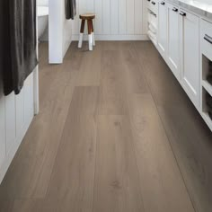 a kitchen with white cabinets and wood flooring