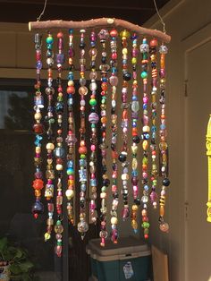 a wind chime hanging from the side of a building with lots of beads on it