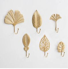 six brass leaf hooks on a white background