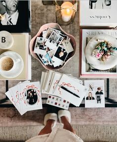 a table topped with pictures and cards next to a cup