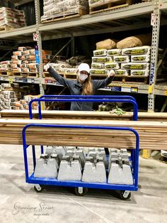 a woman wearing a face mask standing in front of a shelf filled with boxes and other items