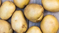 some potatoes are sitting on a wooden surface