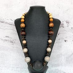 This long bohemian style necklace was hand beaded using a mix of wooden beads in sizes ranging from 10-45mm round.  This necklace features a beautiful ombre color effect, with shades of cream, sand, tan, mocha, chocolate brown, greige, soft gray, and black (a MAJOR 45mm round wooden focal bead).  A truly fresh and modern design!  The necklace measures approximately 29 inches in length and is securely fastened with a sterling silver toggle clasp.  Perfect for any gender!  Length can be adjusted i Cheap Brown Wooden Beaded Necklace, Rustic Brown Wooden Bead Necklaces, Bohemian Brown Long Necklace With Round Beads, Unique Brown Necklace With Large Beads, Rustic Brown Wooden Beaded Necklaces, Brown Necklace With Large Beads, Rustic Brown Wooden Beads Necklace, Brown Wooden Beaded Necklaces For Festivals, Natural Wooden Beads Necklace