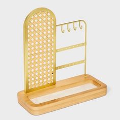 a gold metal and wood desk organizer with hooks on the top, in front of a white background