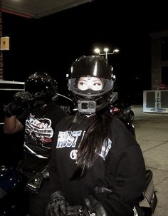 a woman wearing a helmet sitting on a motorcycle