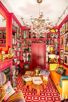 a living room filled with lots of colorful furniture and pictures on the wall above it