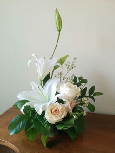 a vase filled with white flowers on top of a wooden table