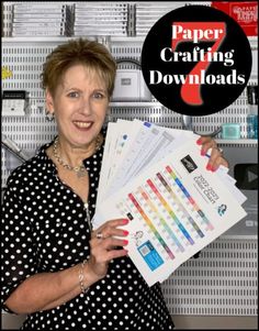 a woman holding up some papers in front of a wall with the words paper crafting downloaded on it