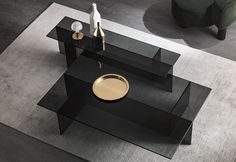 a black and gold coffee table on top of a carpeted floor with two vases next to it