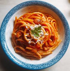 a blue and white bowl filled with pasta