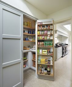 an open pantry door in a kitchen with shelves full of food and condiments