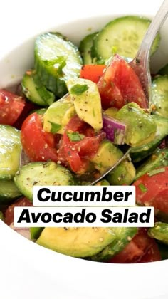 a white bowl filled with cucumber and tomato salad on top of a table