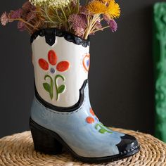 a close up of a boot with flowers in it