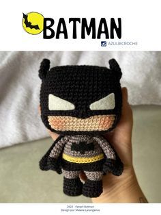 a hand holding a small crocheted batman figure