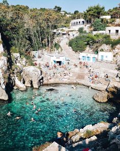 people are swimming in the clear blue water