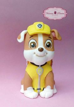 a small toy dog with a yellow hat and leash on it's head sitting in front of a pink background