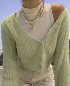 a woman in white pants and a green sweater