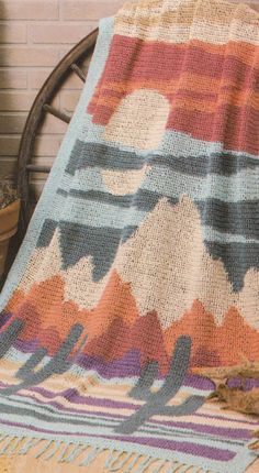 a blanket sitting on top of a chair next to a potted plant in front of a brick wall