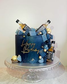 a blue birthday cake with liquor bottles on top