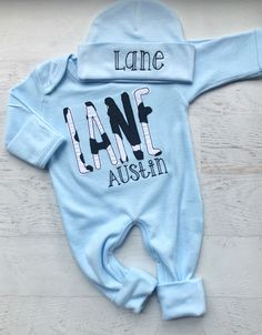 This light blue and cow print baby romper is so sweet for little ones! The black and white cow print, black script middle name, on the soft blue sleeper is so cute for a little farm loving baby! Please leave exact spelling of the childs name. Please double check the spelling as I cannot refund or replace any item for incorrect spelling. Unless otherwise specified, first name name will be in the large appliqué letters, and middle name will be be in the smaller embroidered letters. First name will Fitted Onesie With Name Print For Summer, Fitted Summer Onesie With Name Print, Cute Fitted Onesie With Custom Print, Fitted Black Onesie With Name Print, Customizable Fitted Onesie For Summer, Personalized Fitted Cute Onesie, Fitted Long Sleeve Onesie With Letter Print, Fitted Blue Onesie With Letter Print, Personalized Fitted Onesie For Spring