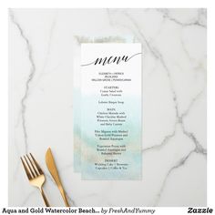 the menu card is on top of a table with gold utensils next to it