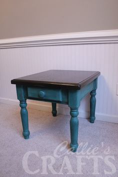 a blue table sitting on top of a carpeted floor next to a white wall