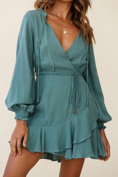 Turn heads in our ultra chic Santorini dress. Partially lined, it features long sleeves with elasticated cuffs, surplice neckline, string tie around the waist and a ruffle hem. Wear it to work teamed with flats and a tote or dress it up with heels... Santorini Dress, Dress Sage, Yellow Bridesmaids, Red Bridesmaids, Blue Bridesmaids, Clothing Tags, Date Night Dresses, Mini Dress Casual, Tie Dress