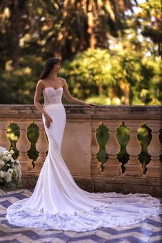 a woman in a wedding dress standing on a balcony