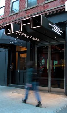 a blurry image of a person walking past a building with neon lights on it