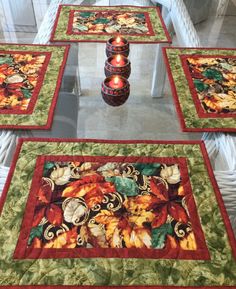 four quilted placemats with candles on them