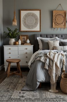 a bedroom with gray walls and white furniture, including a bed covered in grey linens