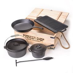 an assortment of pots and pans are shown on a wooden box with a grill