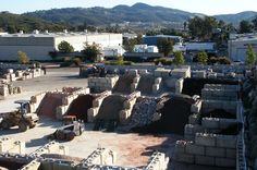 construction work is being done on the roof of an industrial building with mountains in the background