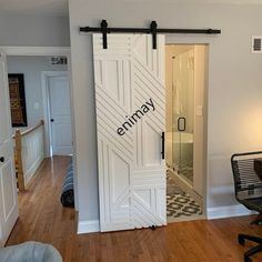 an open door leading to a living room and dining room with hardwood floors, white painted walls and wooden flooring