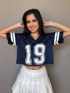 a woman wearing a football jersey with the number 91 on it, posing in front of a wall