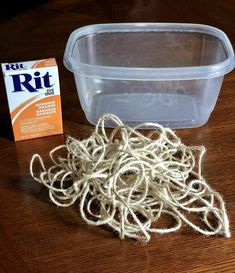 there is a plastic container with rope on the table next to it and a package of rit