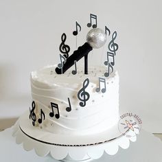 a white cake with music notes on it and a microphone sticking out of the top