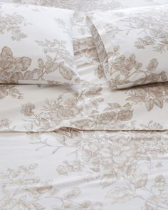 an image of a bed with flowers on the comforter and pillows in it's natural color scheme