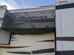 a cat sitting in the window of a motorhome that reads montana on it