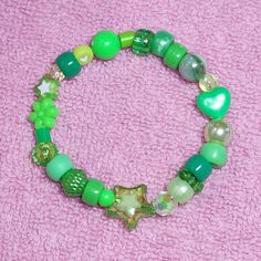 a bracelet with green beads and charms